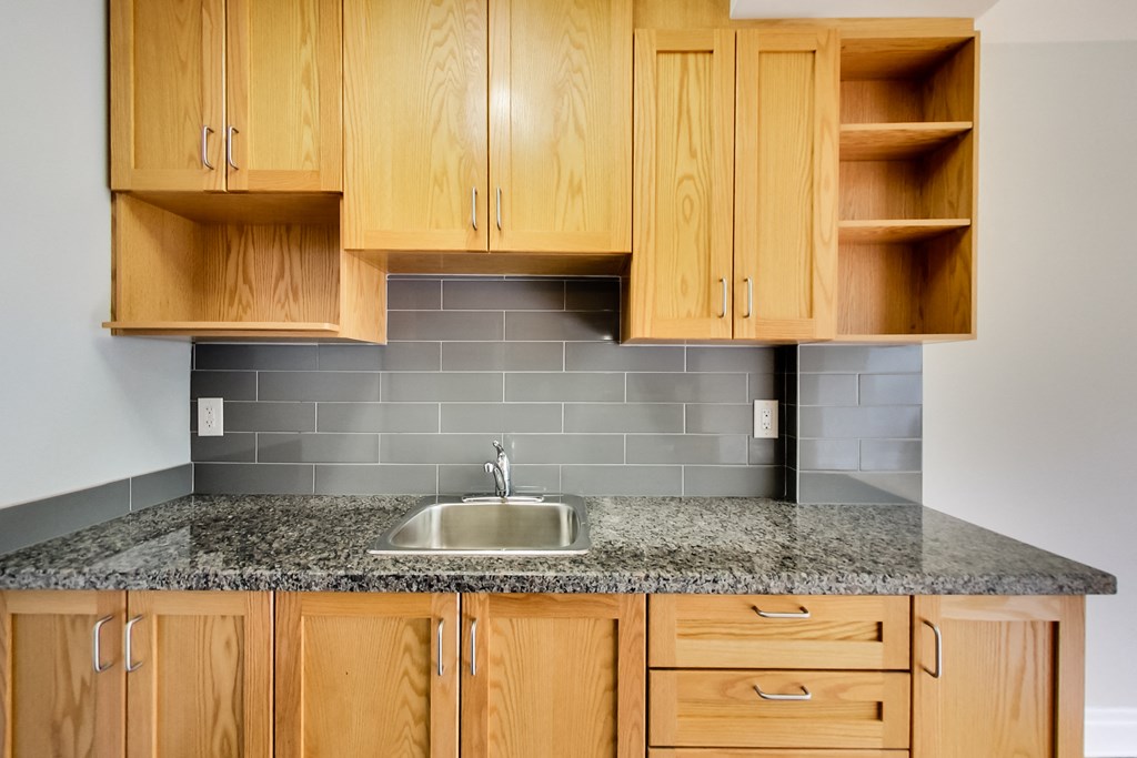 a kitchen with wood cabinets and granite counter top and a sink