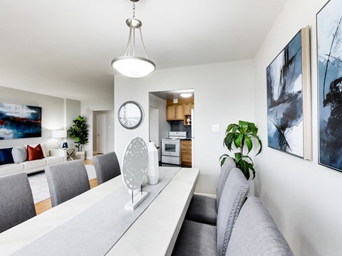 A modern living room with a grey couch and a white table.