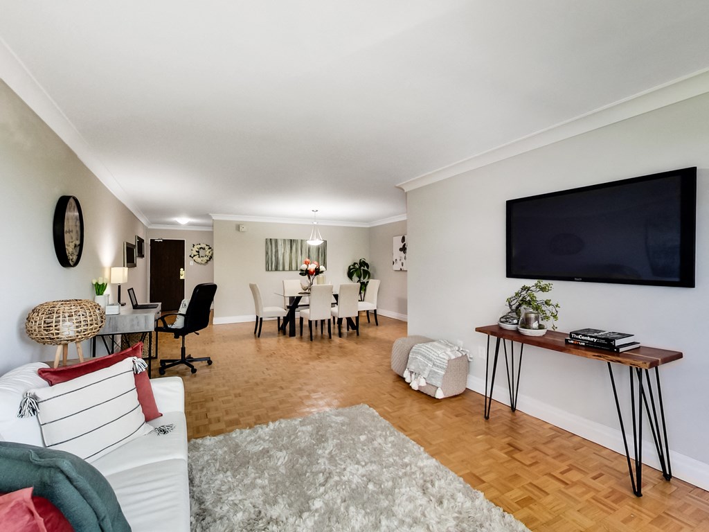 A living room with a white couch and a wooden floor.