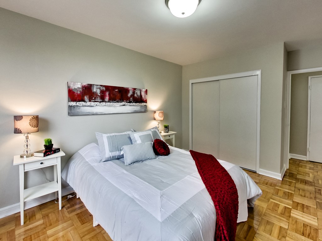 a bedroom with a white bed and a red blanket