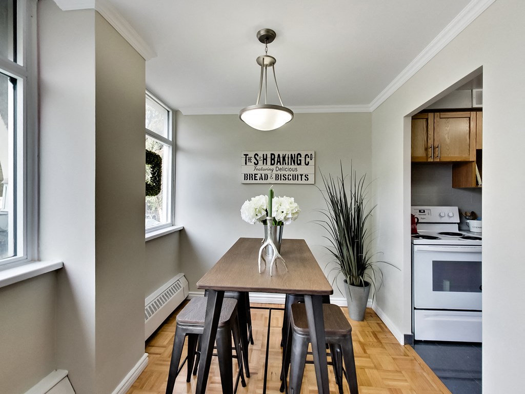 A kitchen with a table and chairs and a sign that says