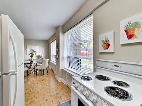 a kitchen with a stove and a refrigerator and a dining room
