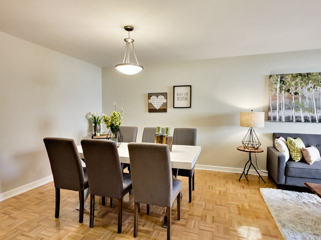 A dining room with a table and chairs.