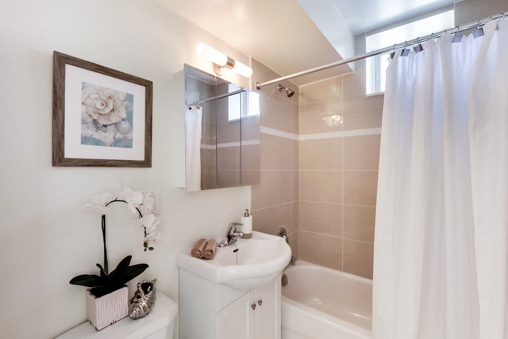 A white bathroom with a white sink and a white bathtub.
