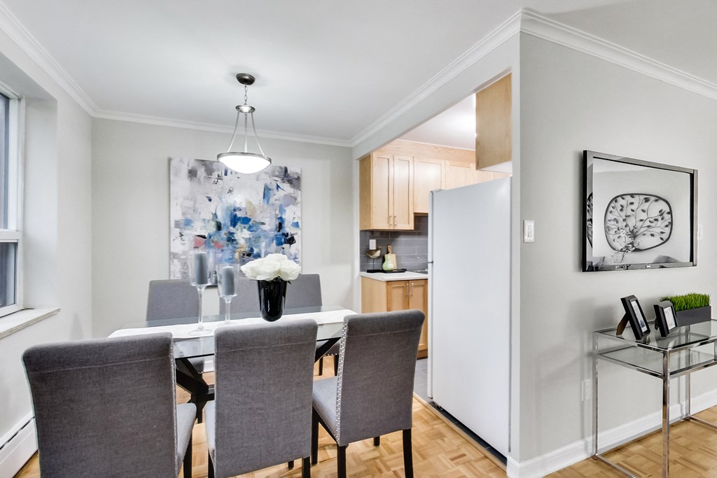 a dining room with a table and chairs and a refrigerator