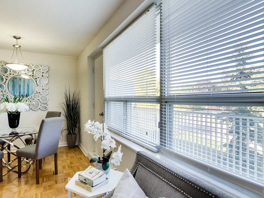 a living room with a large window and a table with a chair