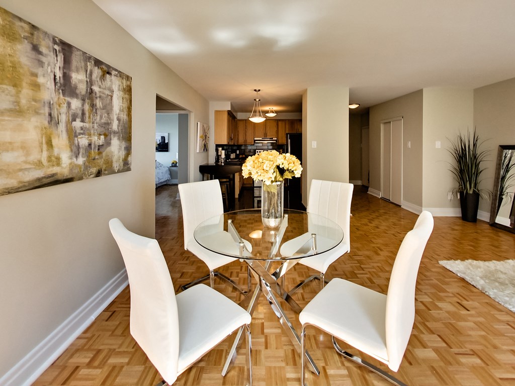 a dining room with a glass table and white chairs