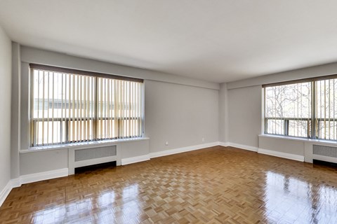 the living room of an empty house with wood floors and windows
