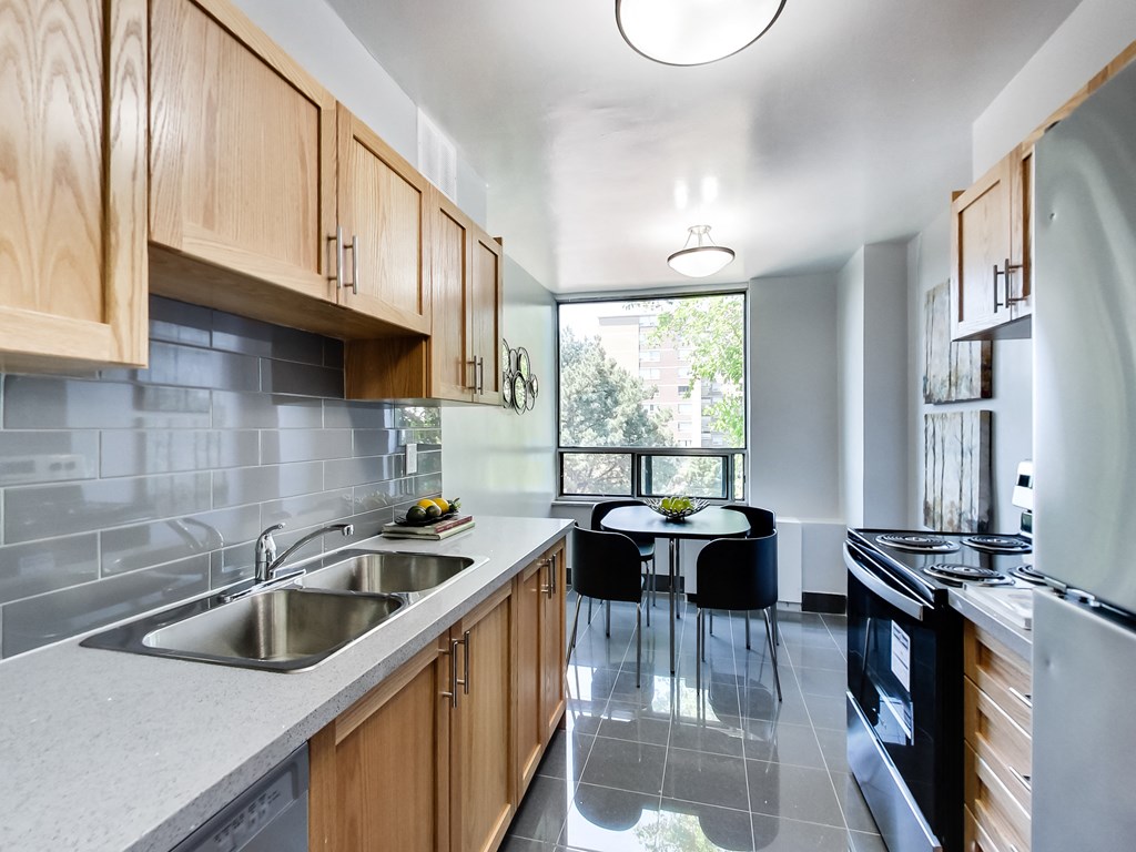 A modern kitchen with wooden cabinets and a large window.