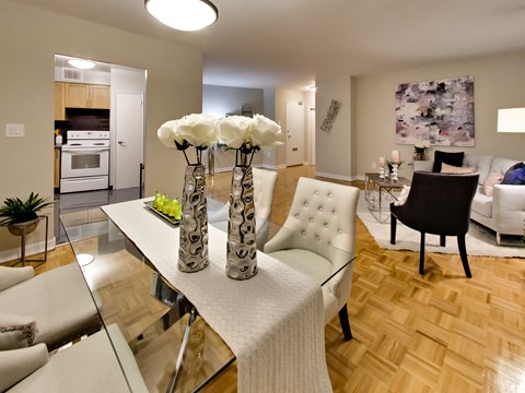 a view of a living room and dining room with a table with three vases
