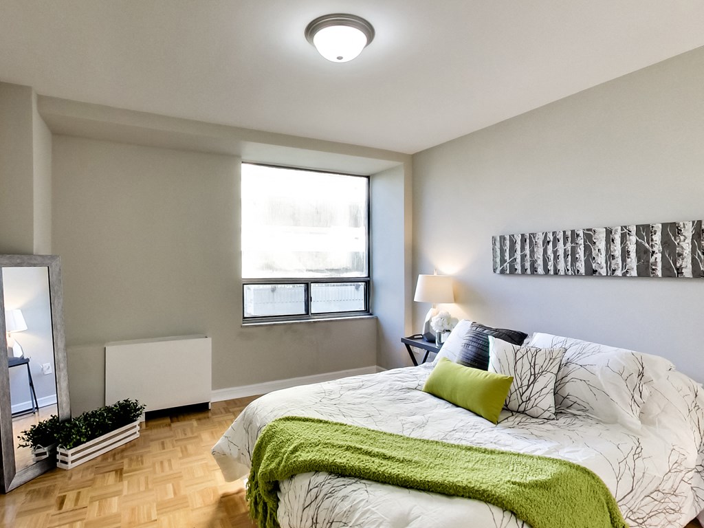 A bedroom with a large bed and a window.