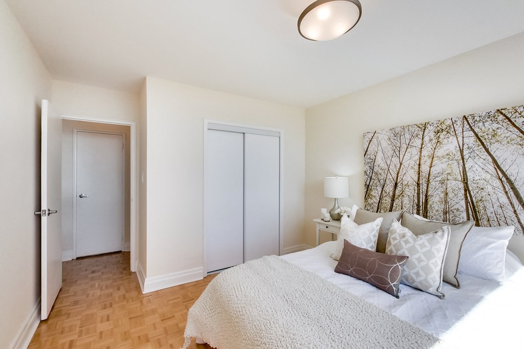 A bedroom with a bed, two pillows, and a lamp.