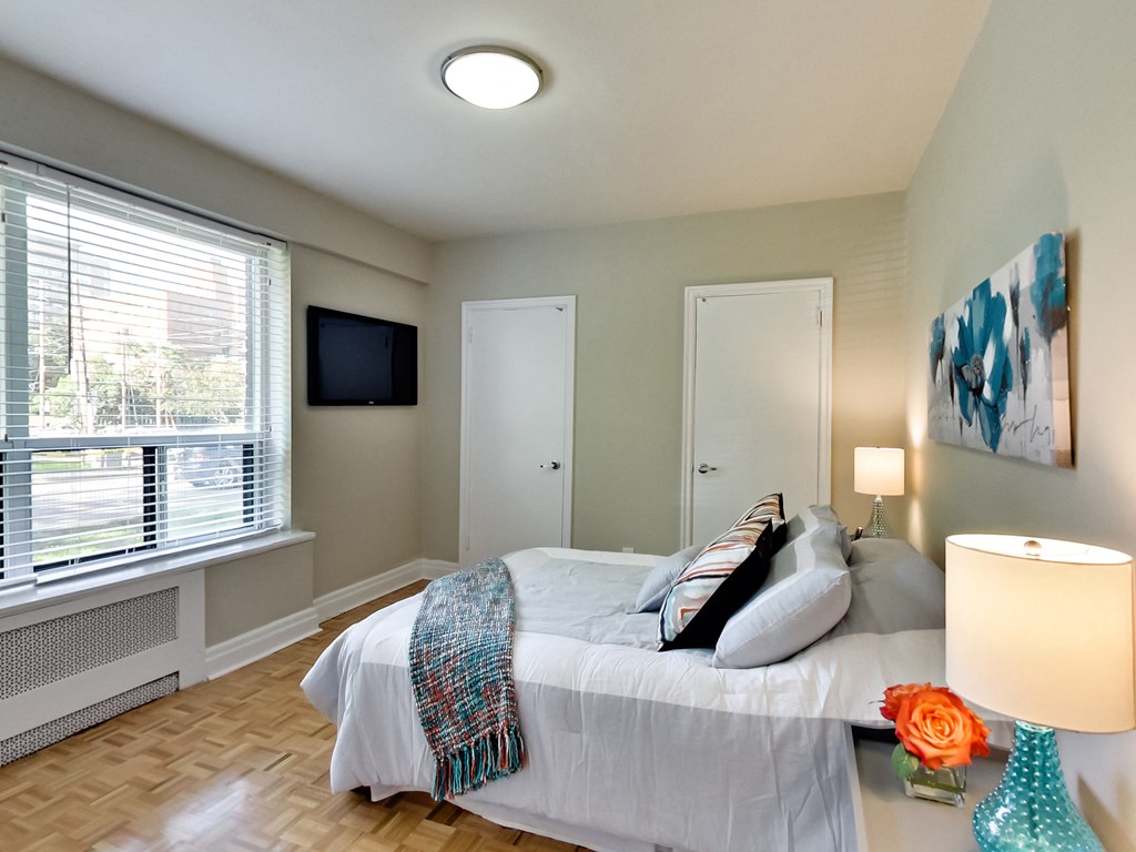 a bedroom with a bed and a tv on the wall