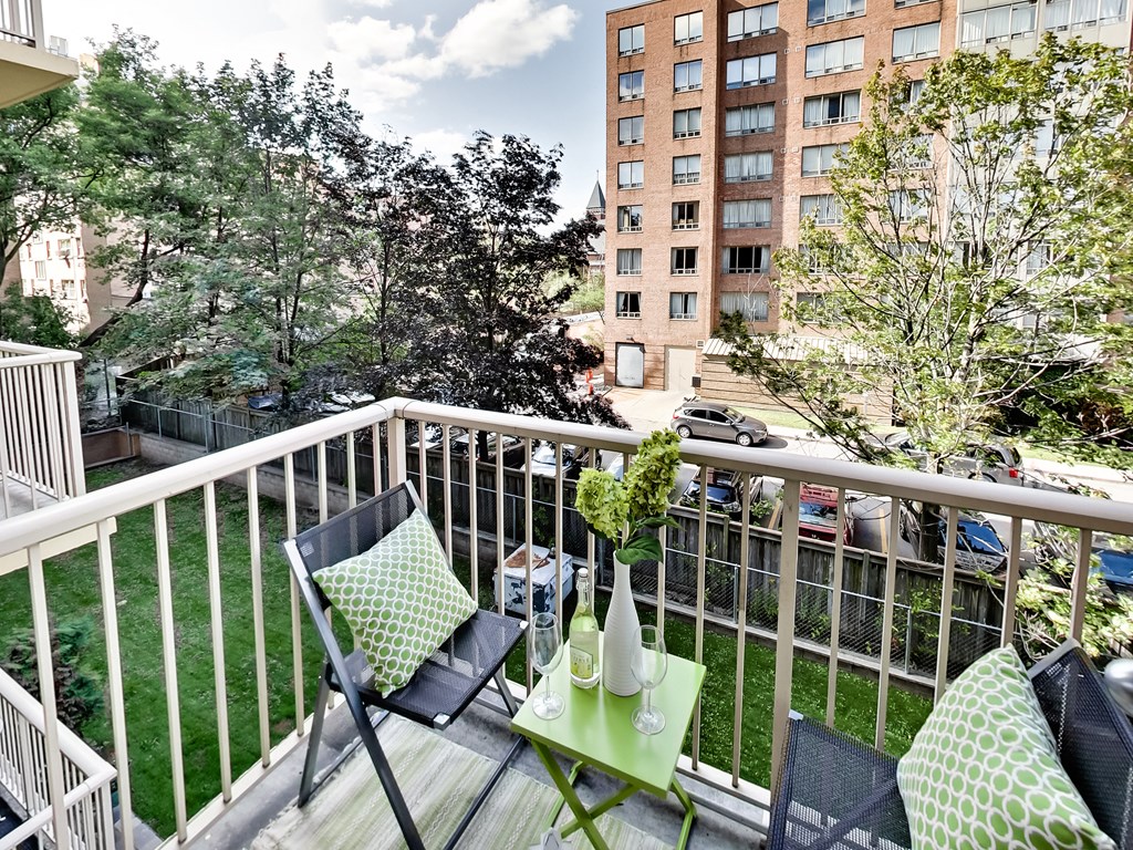a balcony with two chairs and a table on it