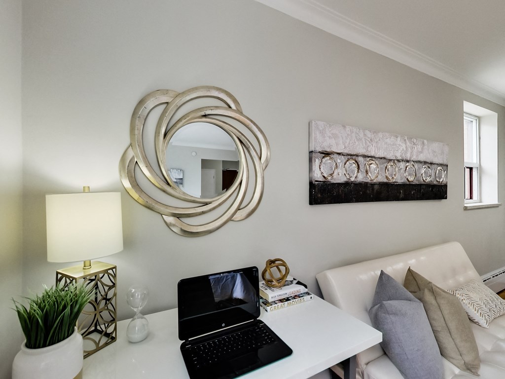 a living room with a laptop and a mirror on the wall