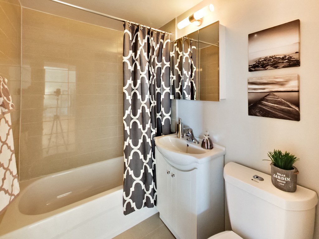 a bathroom with a shower curtain and a toilet and a sink
