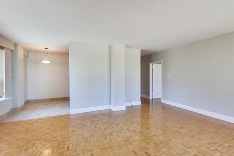 an empty living room with a wooden floor and white walls