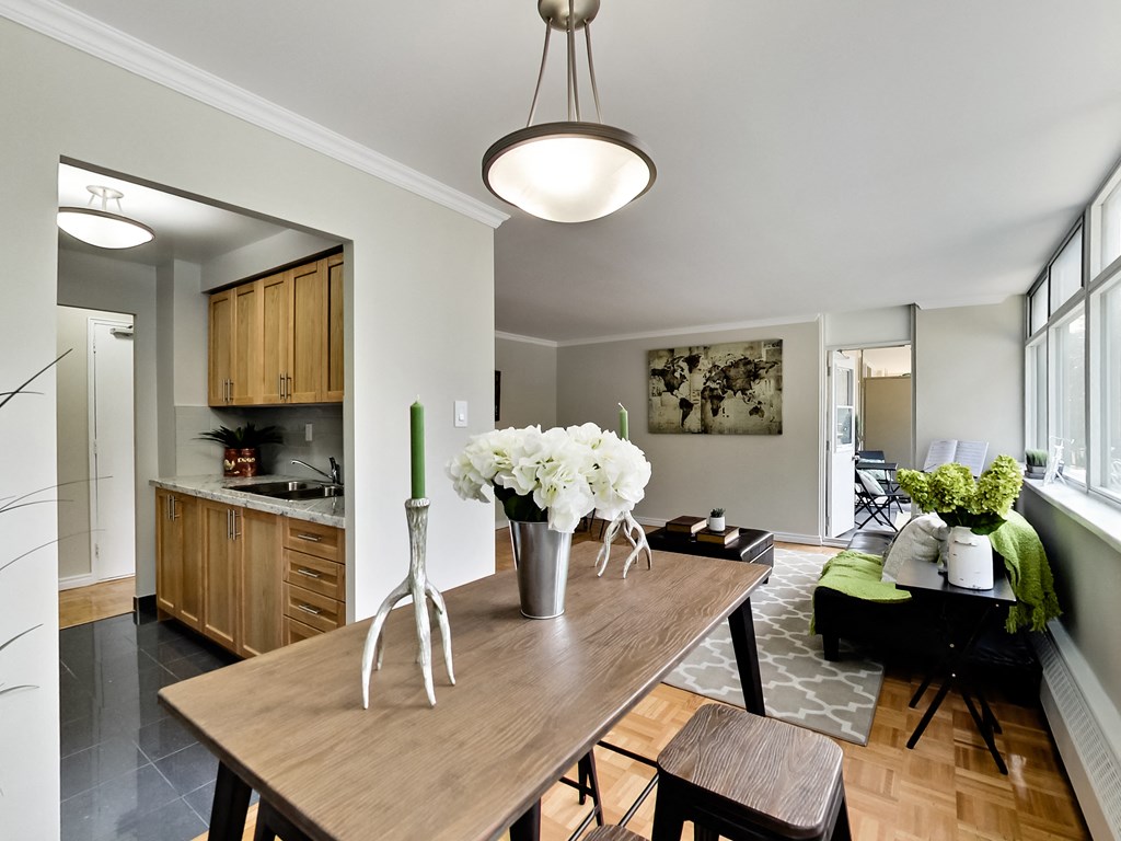 A kitchen with a wooden table and a vase of white flowers on it.