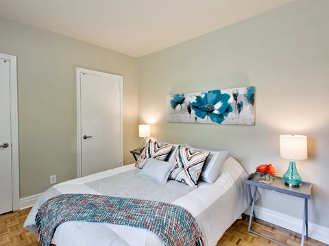 a bedroom with a bed and a painting on the wall