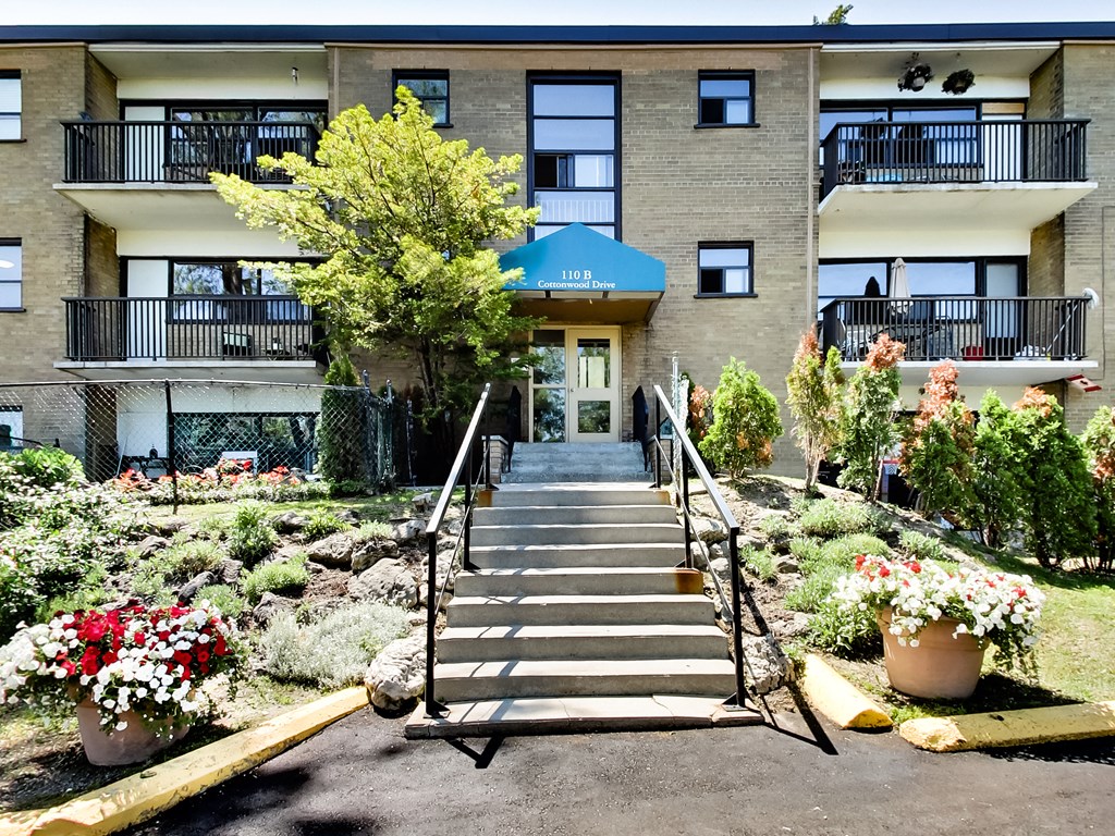 A building with a blue awning and a staircase leading to the entrance.