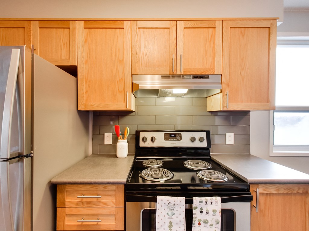 a kitchen with wooden cabinets and a black stove top oven