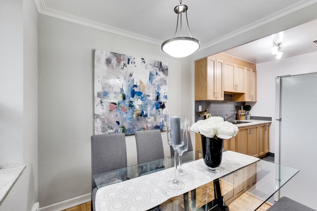a kitchen and dining room with a white counter top and a glass table