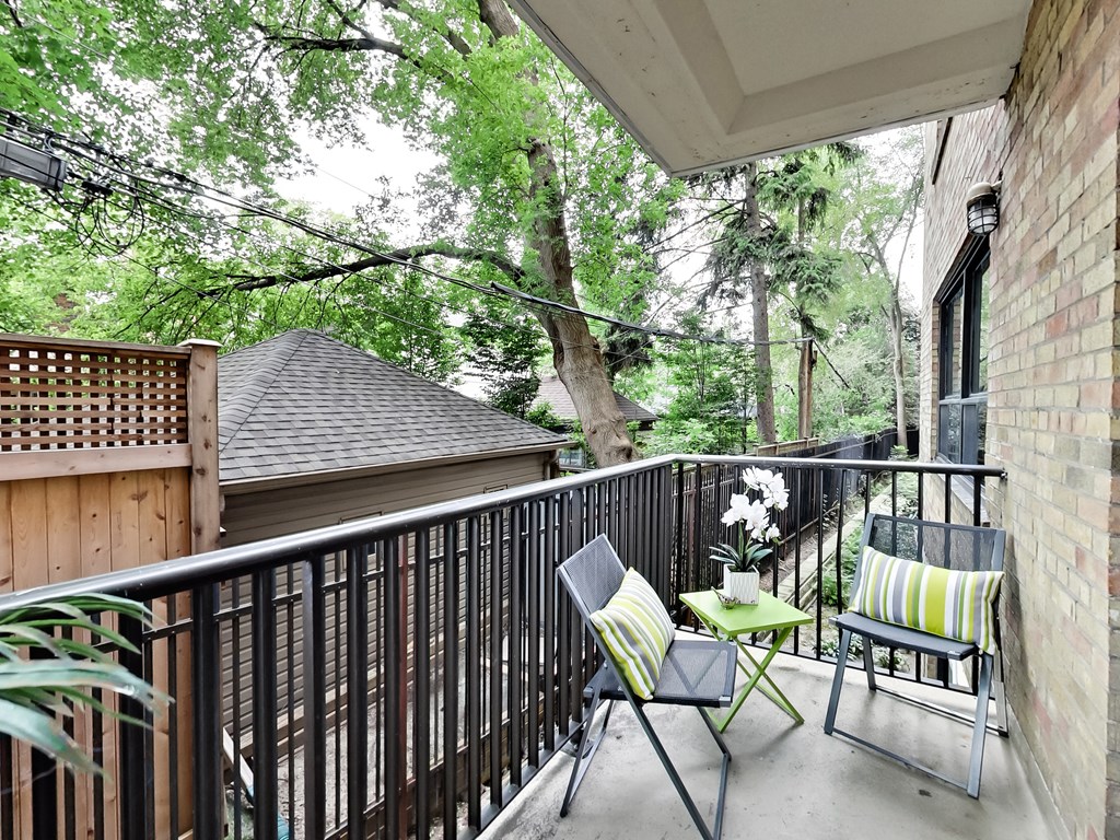 a balcony with two chairs and a table on it
