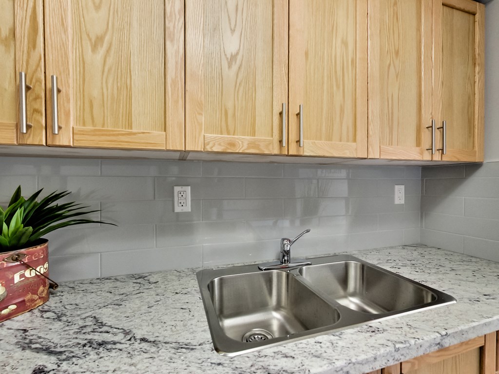 A kitchen with a granite countertop and wooden cabinets.
