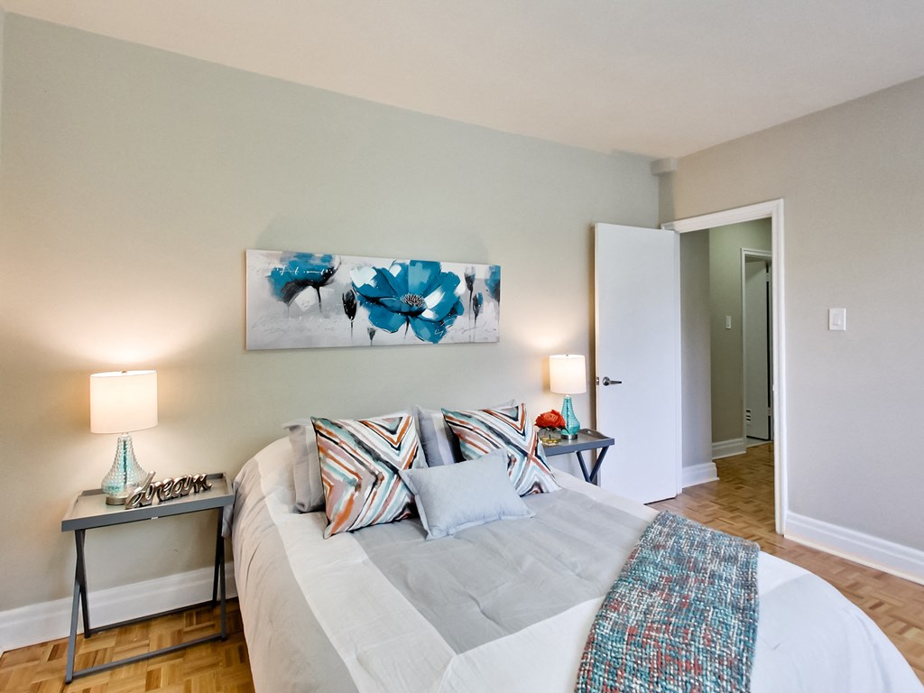 a bedroom with a large bed and a painting on the wall