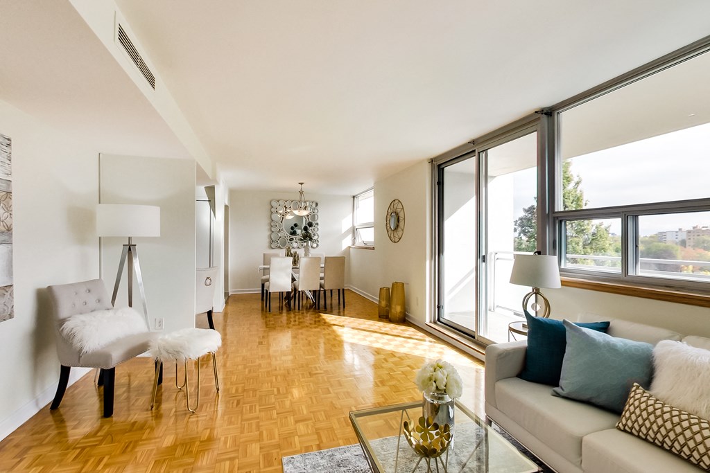 A living room with a white couch and a wooden floor.
