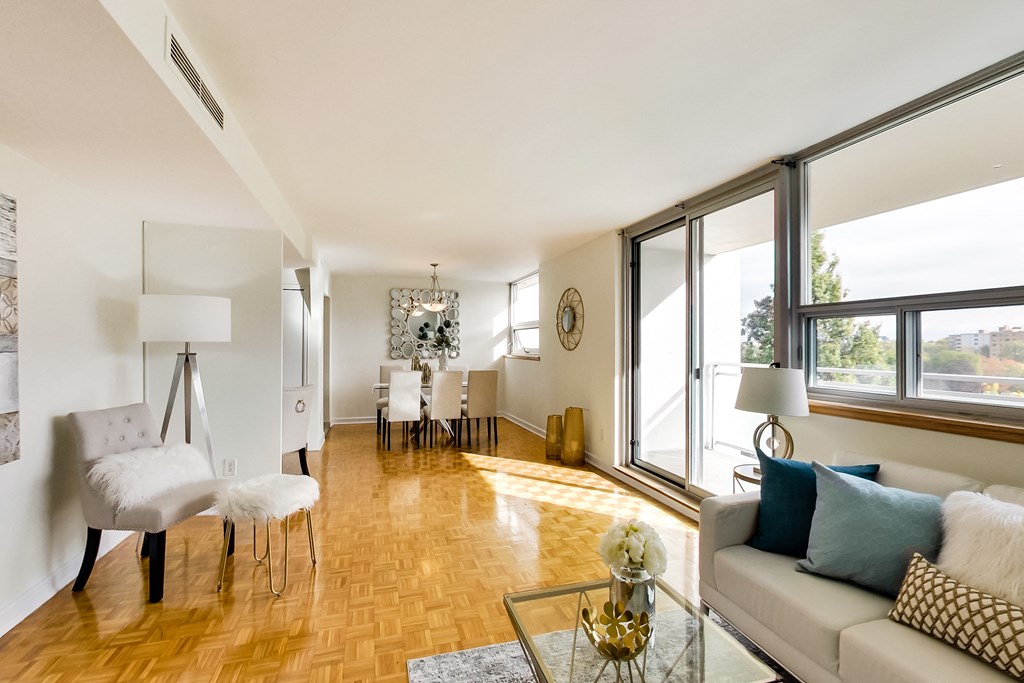 A living room with a white couch and a wooden floor.