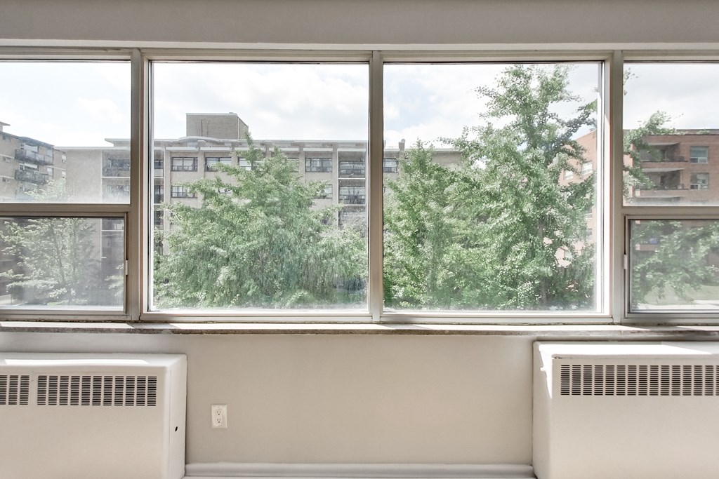 a room with a large window and a view of trees