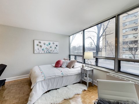 A bedroom with a large bed and a painting on the wall.