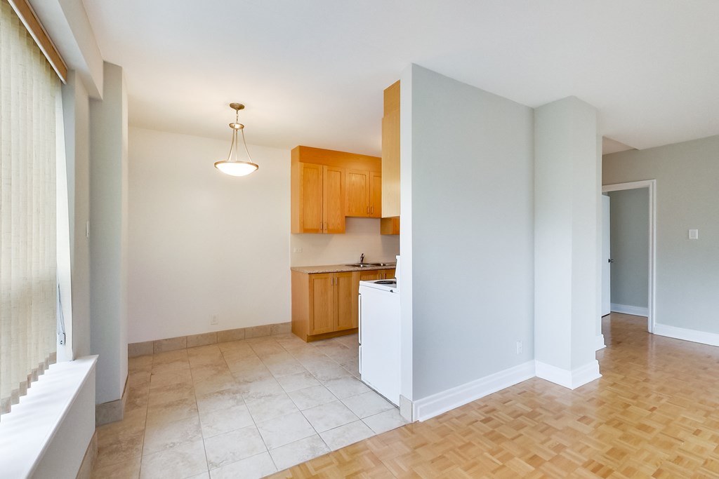 an empty living room and kitchen with a wood floor