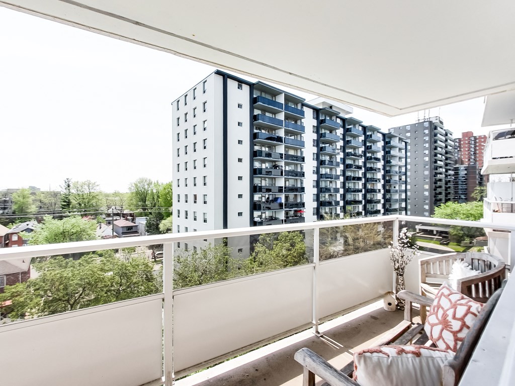 A balcony with a couch and a view of a cityscape.