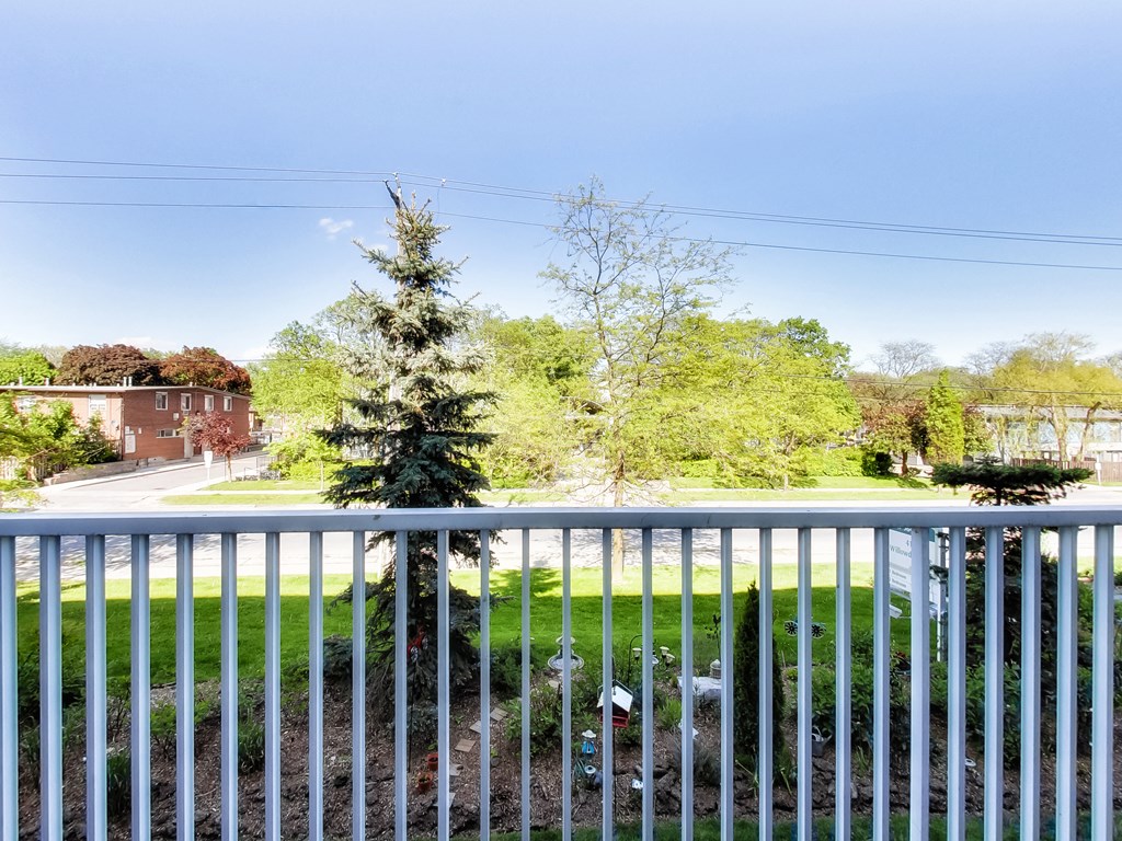 a view from a balcony of a yard with a tree