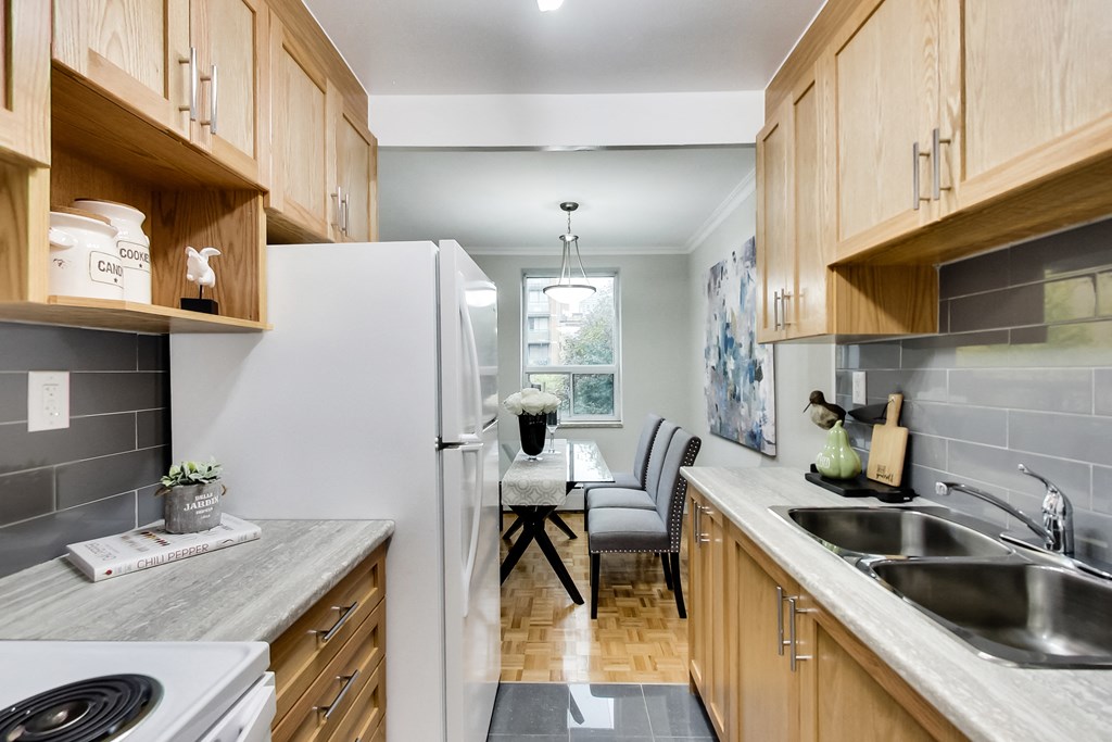 a kitchen with wooden cabinets and white appliances and a dining room table