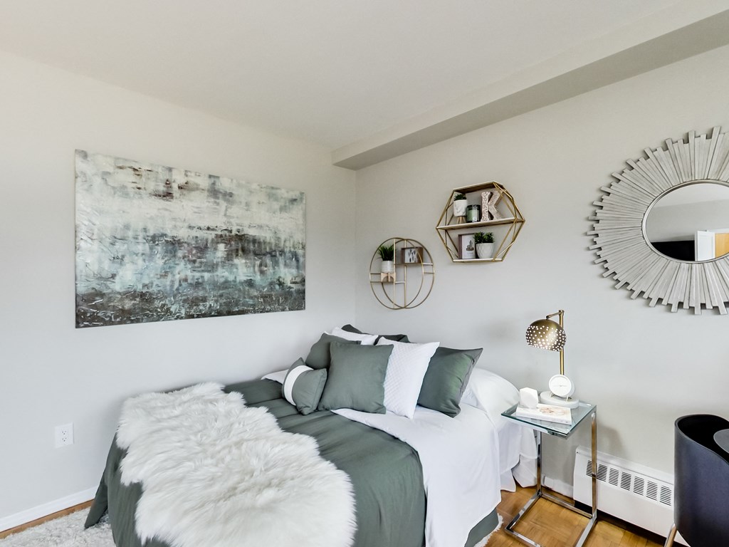 A bedroom with a large bed and a painting on the wall.