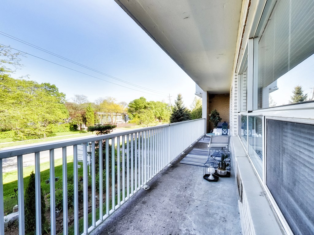 the view from the balcony of a large apartment building with a view of the yard