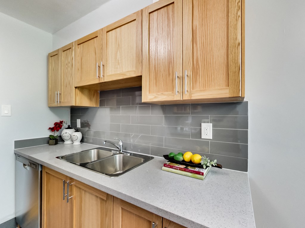 A kitchen with wooden cabinets and a grey countertop.