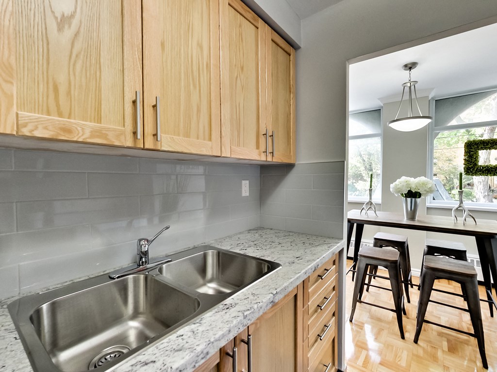 A kitchen with a sink and wooden cabinets.