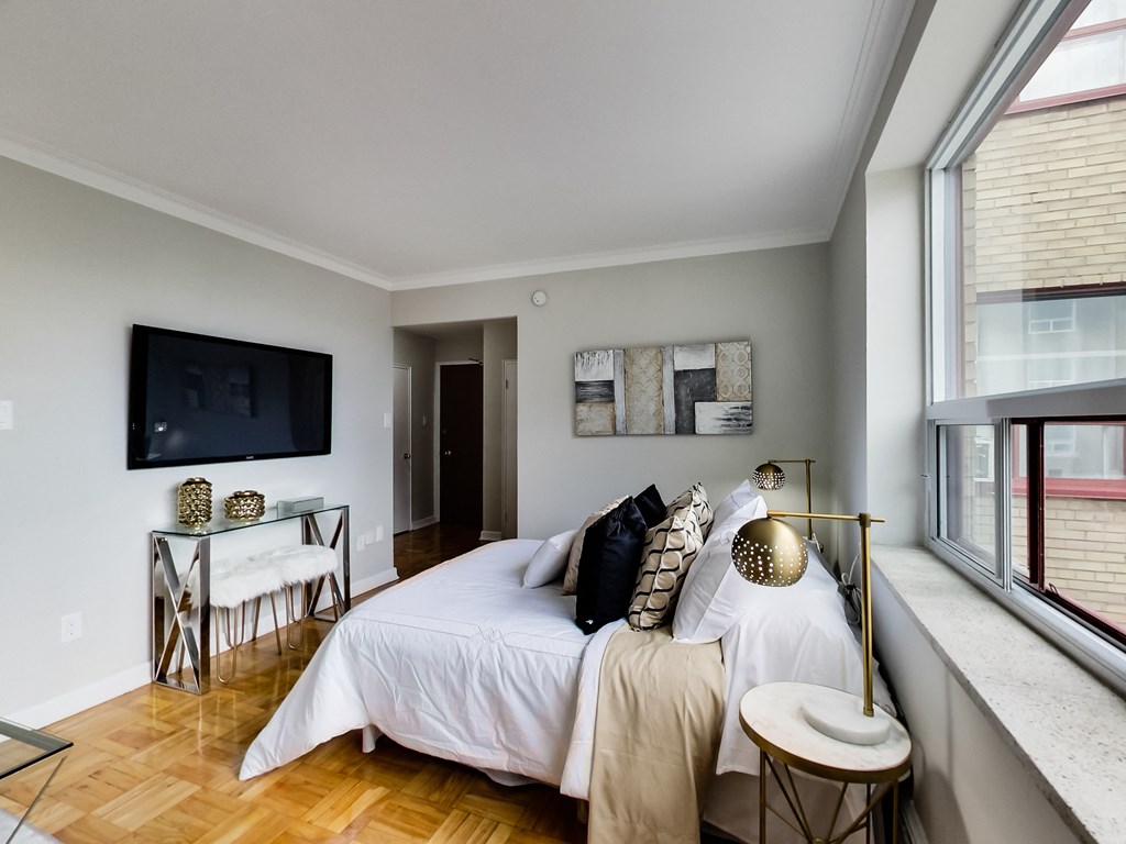 a bedroom with a bed and a tv on the wall