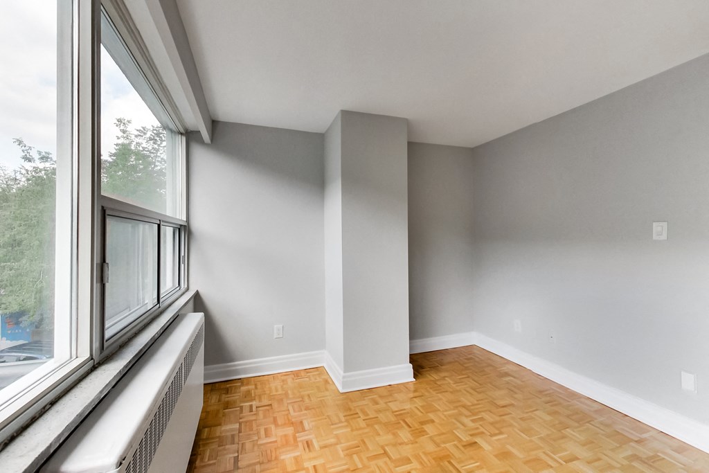 an empty room with a large window and wood flooring