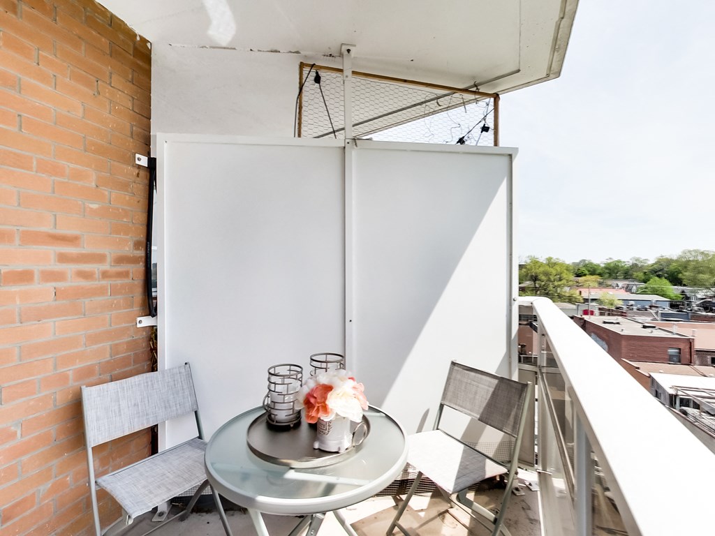 A table with chairs and a vase on a balcony.