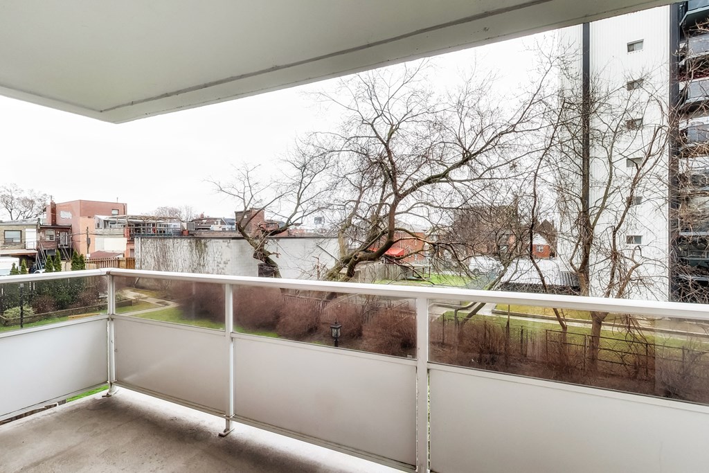 A balcony with a white railing overlooks a residential area.