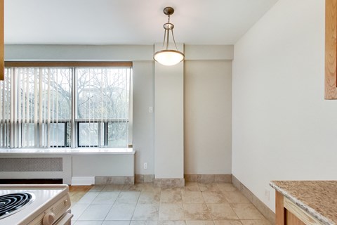 an empty kitchen with a window and a stove and a counter top