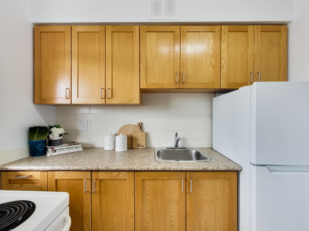 A kitchen with wooden cabinets and a white refrigerator.