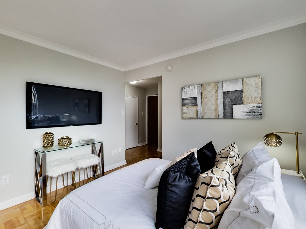 a bedroom with a large bed and a tv on the wall