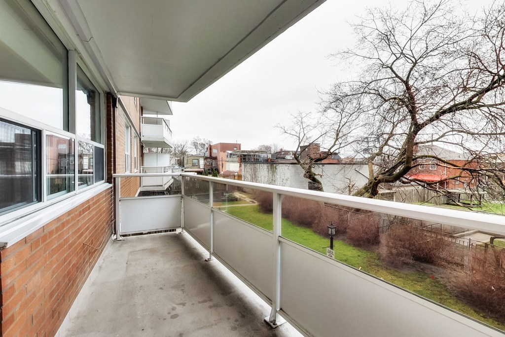 A balcony with a white railing and a view of a residential area.