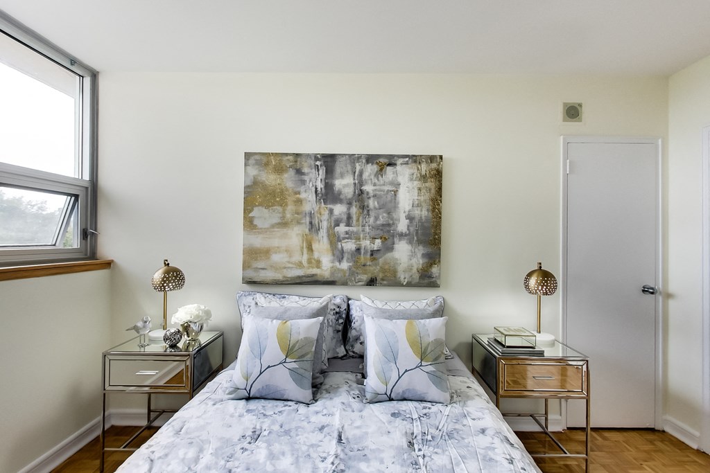 A bedroom with a large bed and a painting on the wall.